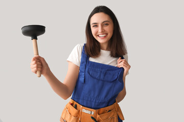 Sticker - Female plumber with plunger on grey background