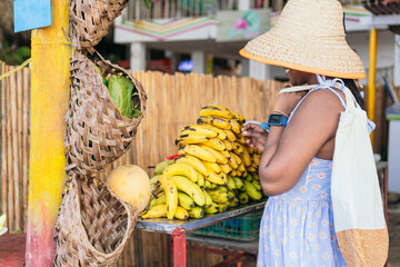 Wall Mural - Black Woman buying fruit with reusable cloth bags in supermarket