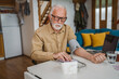 © Miljan Živković - Man senior caucasian male use device to measure blood pressure at home