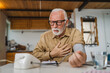 © Miljan Živković - Man senior caucasian male use device to measure blood pressure at home