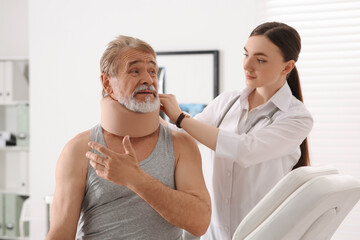 Canvas Print - Orthopedist applying cervical collar onto patient's neck in clinic