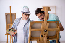 Old Painter Teaching Young Student At Studio