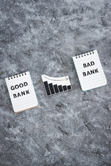 Wall Mural - Good bank vs Bad Bank insolvency and closing down, notepad with text and graph showing negative stats