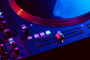 Wall Mural - Close up of DJ mixing console in party light