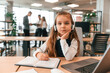 © standret - Sitting by the table with laptop. Little girl is in the office where people working together