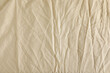 © New Africa - Crumpled beige fabric as background, top view