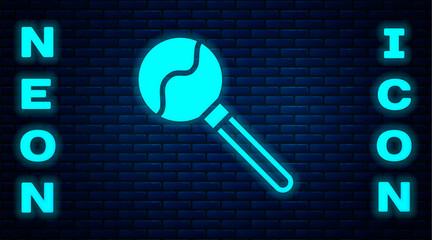 Wall Mural - Glowing neon Lollipop icon isolated on brick wall background. Food, delicious symbol. Happy Halloween party. Vector