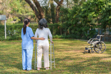 Wall Mural - Beautiful Asian nurse taking patient walk in physiotherapy park for exercise and relaxation