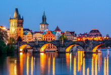 Prague Medieval Architecture And Charles Bridge Over Vltava River At Night, Czech Republic