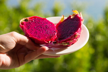 Dragon fruit with red pulp close-up on a platter.