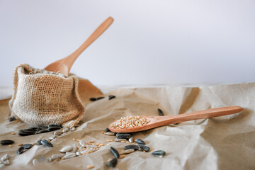 bag with sunflower seeds and two wooden spoon