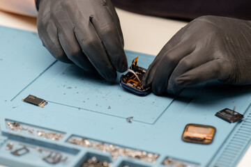 smart watch being repaired by an engineer Workshop for the repair of phones and equipment Phone and equipment repair shop An employee repairs a smart watch