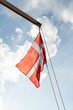 Low angle of the waving flag of Denmark with the bright sky in the background
