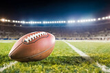 Fototapeta Sport - Ball of american football on green field of stadium in the night