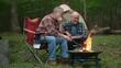 © Robert Peak - Closeup of two gay men in front of campfire laughing and smiling celebrating pride.
