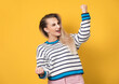© Alen-D - Profile of excited young woman with closed eyes and clenched fists, isolated on yellow background. Yes concept. Pretty girl celebrates success