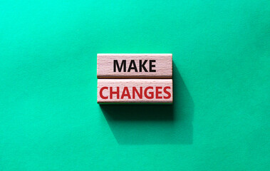 Wall Mural - Make changes symbol. Wooden blocks with words Make changes. Beautiful green background. Business and Make changes concept. Copy space.