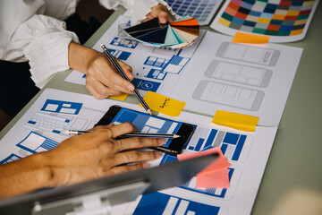 Close up ux developer and ui designer use augmented reality brainstorming about mobile app interface wireframe design on desk at modern office.Creative digital development agency