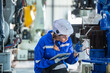 © BESTIMAGE - woman technician engineer check heavy machine construction installation in industrial factory. technician worker check for repair maintenance electronic operation manufacture factory plant industry