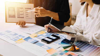 Close up ux developer and ui designer use augmented reality brainstorming about mobile app interface wireframe design on desk at modern office.Creative digital development agency