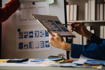 Close up ux developer and ui designer use augmented reality brainstorming about mobile app interface wireframe design on desk at modern office.Creative digital development agency