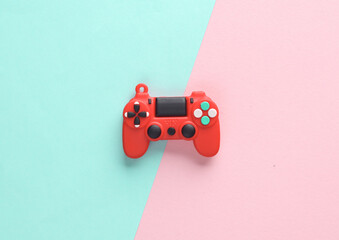 Canvas Print - Red toy miniature gamepad on a pink blue background. Top view