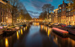 Canal at night in Amsterdam in Holland, Netherlands, Generative AI.