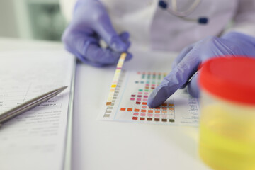 Wall Mural - Worker checks results of urine test looking at color palette