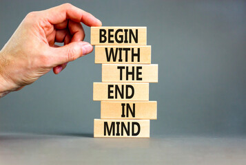 Begin in end of mind symbol. Concept words Begin with the end in mind on wooden blocks. Beautiful grey table grey background. Businessman hand. Business begin in end of mind concept. Copy space.