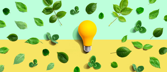 Wall Mural - Yellow light bulb with green leaves - Flat lay