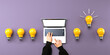 © Tierney - Idea light bulbs with person using a laptop computer from above