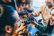 © Nicolas Micolani - Happy group of friends  toasting and drinking red wine together at bar restaurant table- Young multiracial people enjoying at happy hour cheering glasses- Beverage and lifestyle concept with teenager