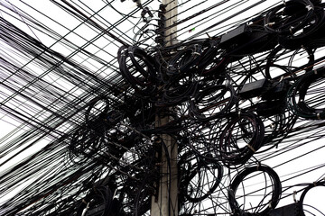 Many electrical cable are tangled on an electric pole.