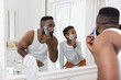 © Wavebreak Media - Happy african american father and son shaving beard in bathroom