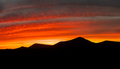 Wall Mural - Beautiful and dramatic sunset colours over the volcanic mountain range near Corralejo in Fuerteventura Canary Islands Spain