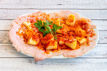 Wall Mural - Once at the point of salt, the Galician ham is cooked and, once cold, cut into slices and seasoned with oil and paprika and served with cachelos