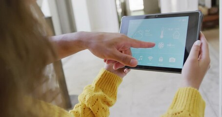 Wall Mural - biracial couple spending time at home using tablet with smart home interface