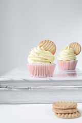 Sticker - Pink cupcakes with tall american buttercream swirl and cookie garnish, cupcakes in pink liners with a tall vanilla buttercream and a cookie, birthday cupcakes on a white background