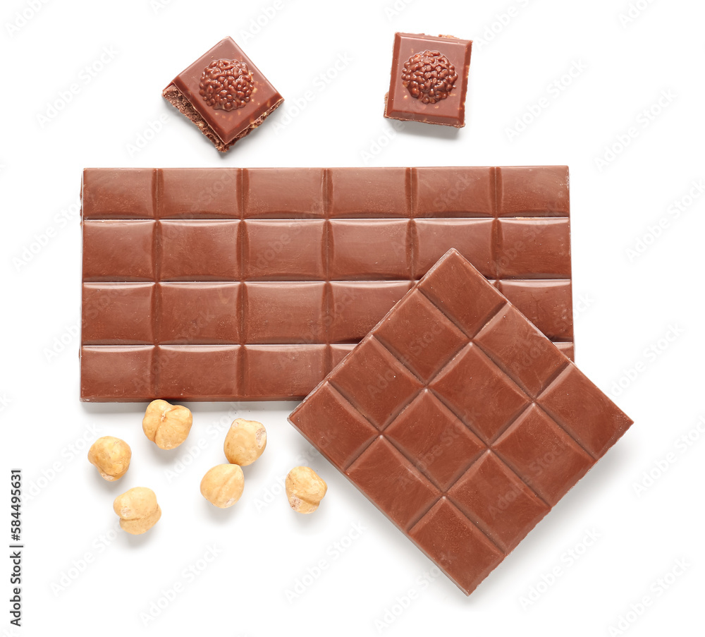 Tasty chocolate and hazelnuts on white background