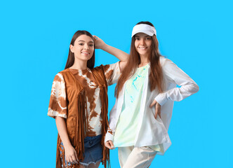 Wall Mural - Stylish young women in tie-dye t-shirts on light blue background