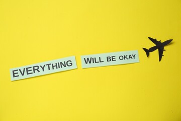 Wall Mural - Cards with phrase Everything Will Be Okay and paper cutout of plane on yellow background, flat lay