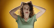 © andreybiling - Young woman over isolated background suffering from headache desperate and stressed because pain and migraine. Hands on head. Portrait of beautiful stressed woman on yellow color background.