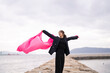 © peach100 - 海でピンクの布を持った女性
