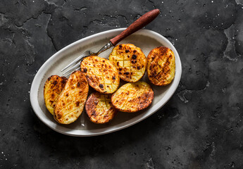 Wall Mural - Barbecue grilled potatoes on a dark background top view