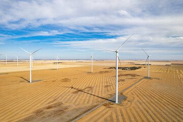 Looking down the road of a wind farm populated by wind turbines