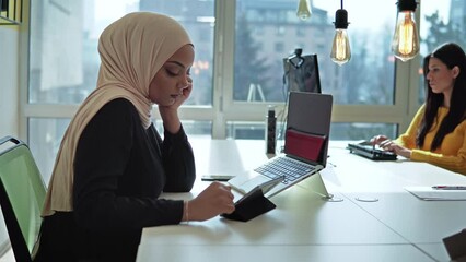Beautiful muslim business woman brown hijab working about financial with business report and calculator in home office.