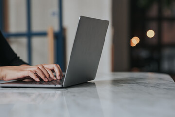 Wall Mural - Female hands typing on laptop keyboard.