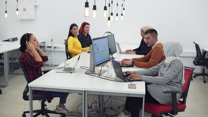Group of business multicultural people and software developers working as a team in startup coworking office