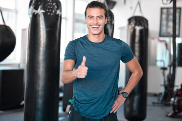 Wall Mural - Laughing, thumbs up and portrait of man in gym for success, motivation or workout. Comic, hand gesture or happy male athlete with emoji for yes, like or approval, agreement or fitness, goal or target