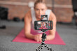 © Phindulo T/peopleimages.com - Live streaming, fitness and phone of woman exercise, pilates or workout on social media or video platform on tripod. Gen z athlete, sports influencer or content creator training on smartphone screen
